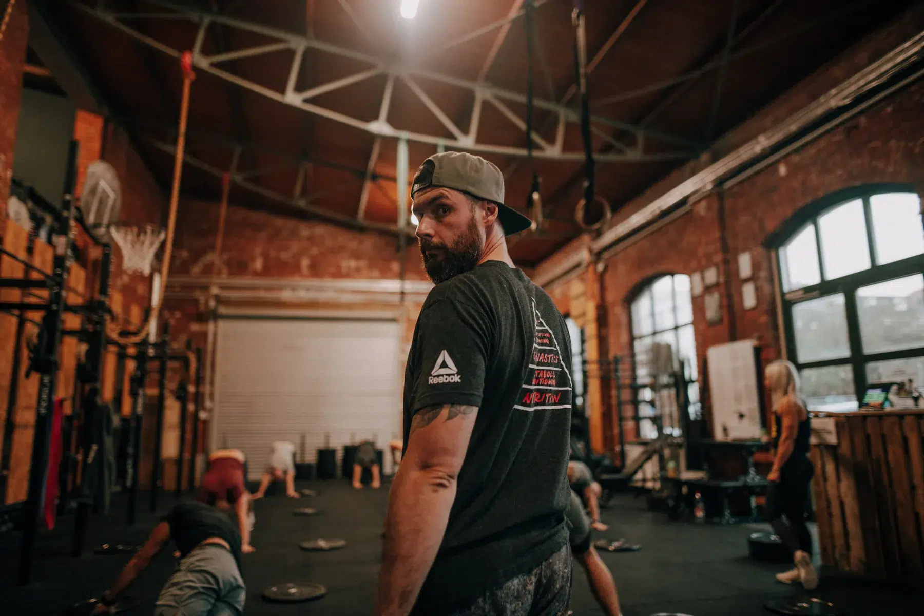 CrossFit-Coach beobachtet eine Trainingseinheit in der Backsteinhalle von CrossFit 108